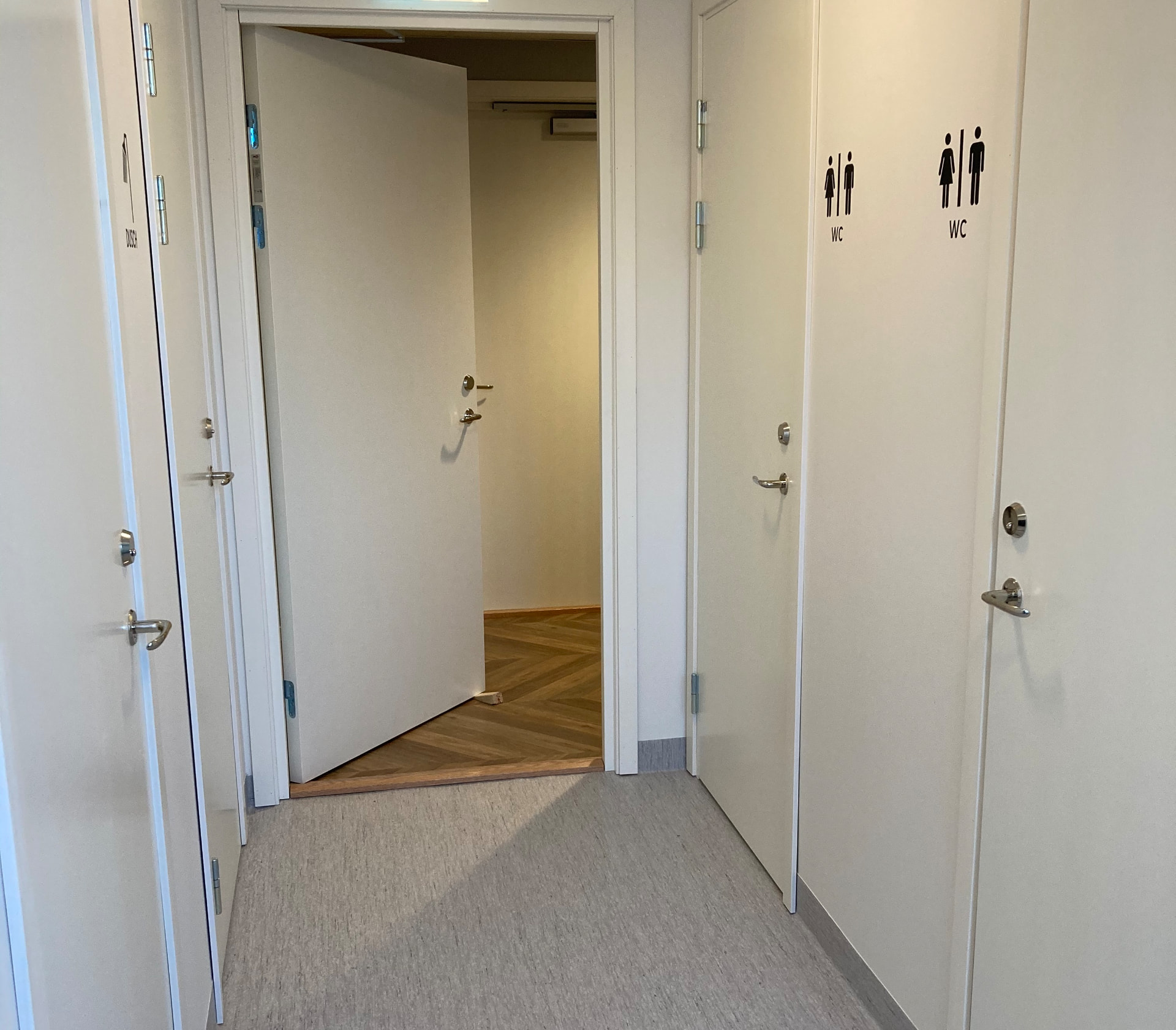 Corridor with doors to individual lockable shower and toilet rooms