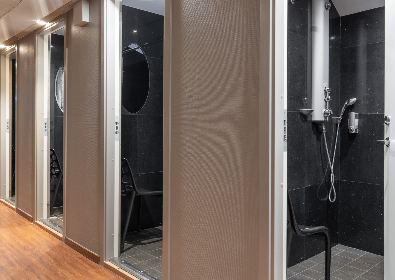 Corridor with individual lockable shower rooms at Mini-Hotel