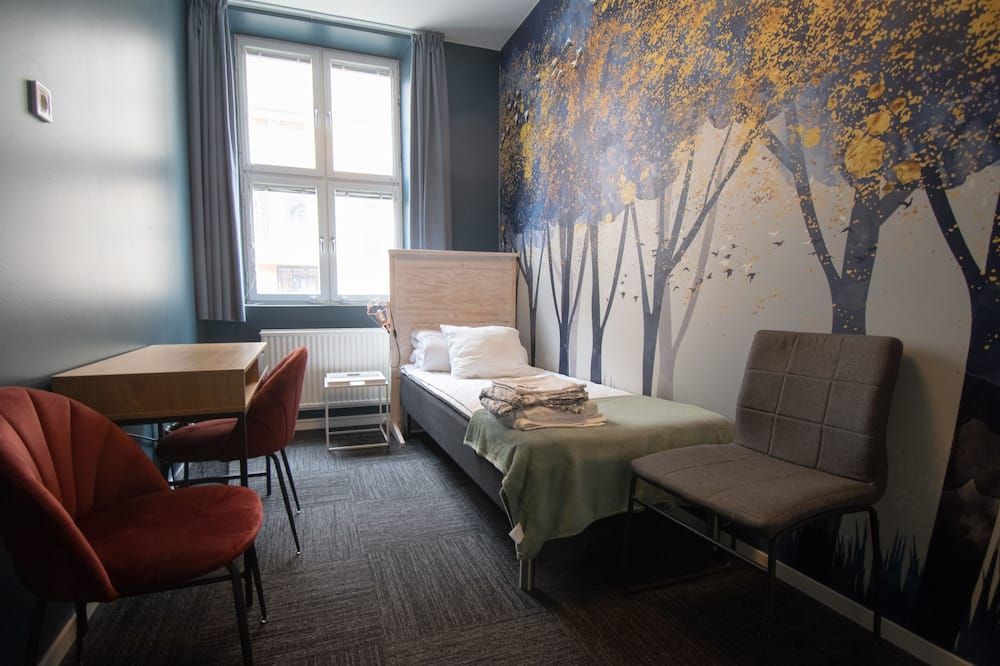 Single room with bed, desk and wardrobe at Mini-Hotel Borås