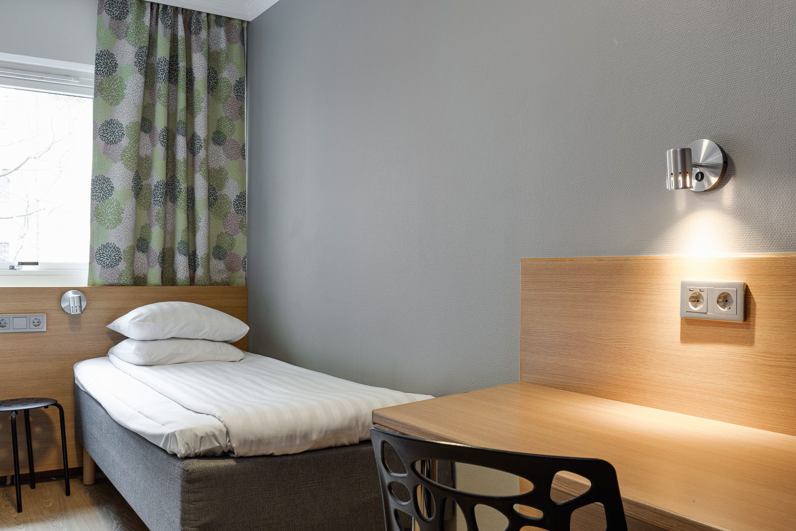 Enkelrum med säng, skrivbord och garderob på Mini-Hotel Göteborg